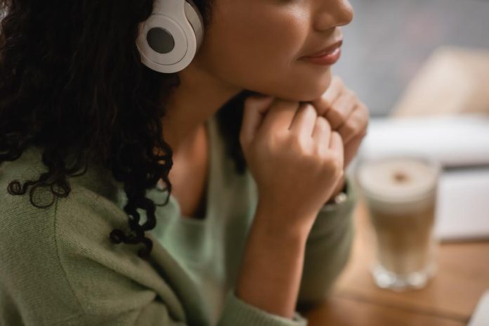 middle-aged, Black woman listening to podcast