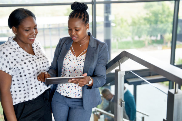 two Black women looking at tablet