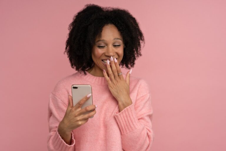 black woman giggling looking at phone