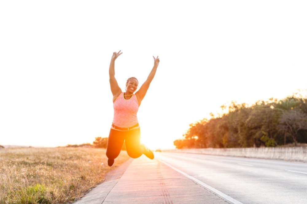 Aging Black woman jumping up.
