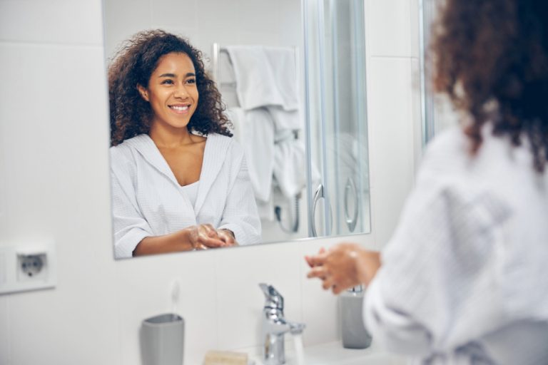 Black woman saying affirmations in mirror.
