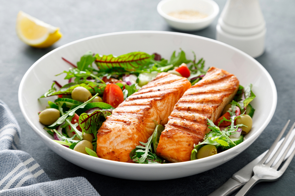 Best Foods To Eat After Giving Birth- salmon on a bed of greens