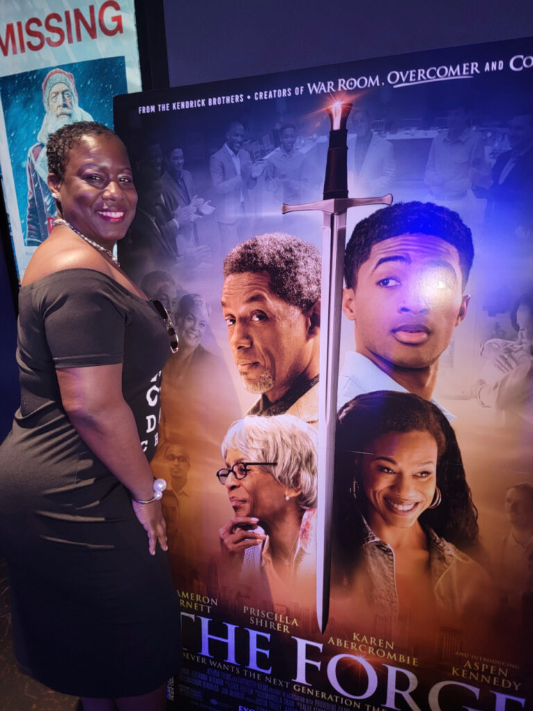 Lady Tiffany Nicole in front of The Forge movie backdrop.