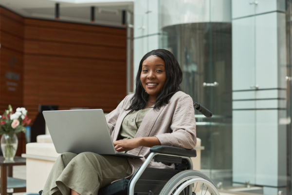Black woman in wheelchair excited to be climbing the career ladder.