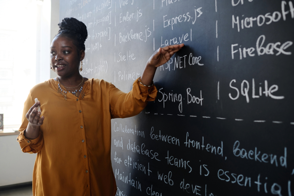 Black educator practicing public speaking while teaching students.
