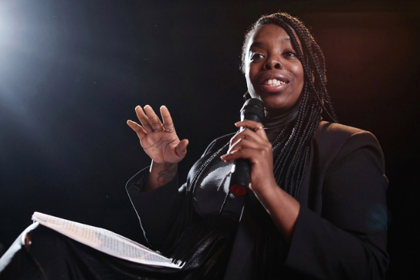 Black woman public speaking on stage.