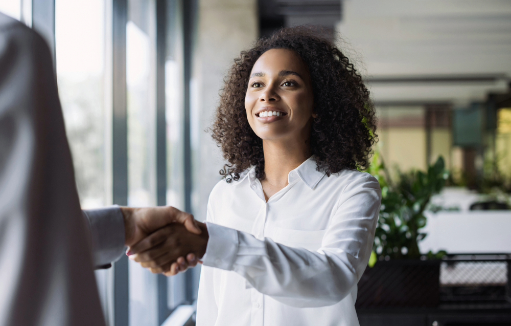 Black woman shaking hands after an interview she found on SwagHer Jobs.