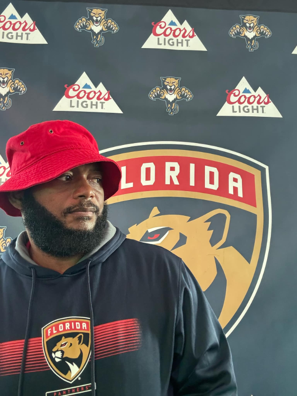 DJ Rob in front of Panthers backdrop.