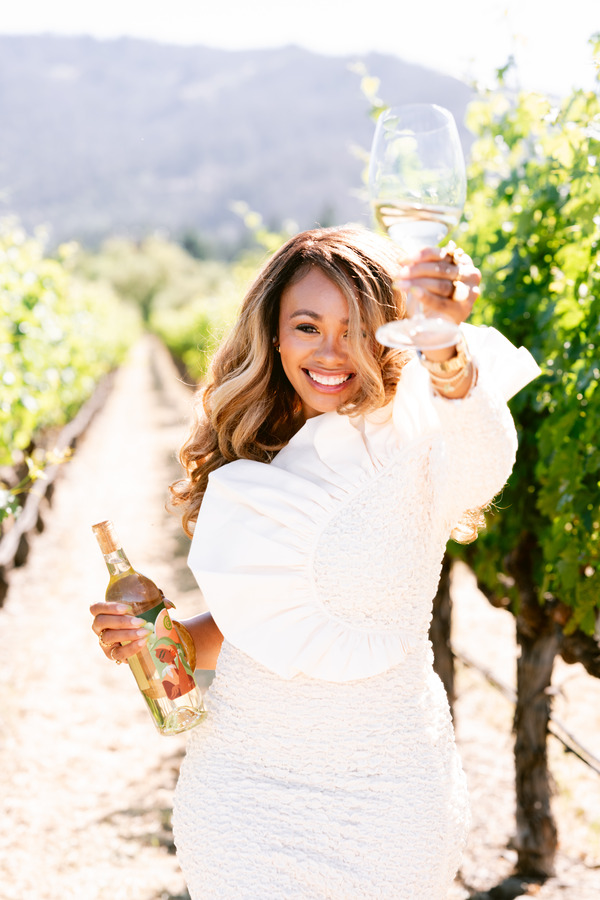Reyna Noriega with a wine bottle she designed to spread joy.