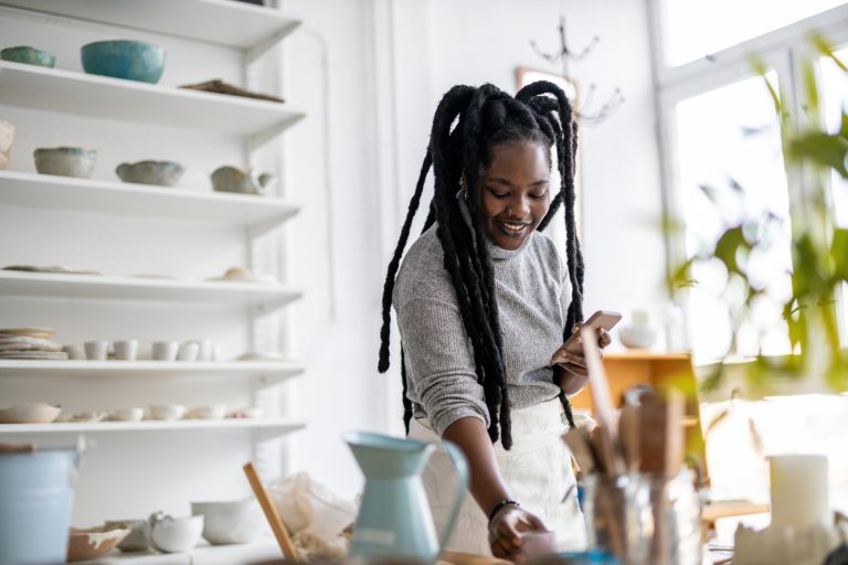 Black woman pottery maker working and scaling her business at the same time.