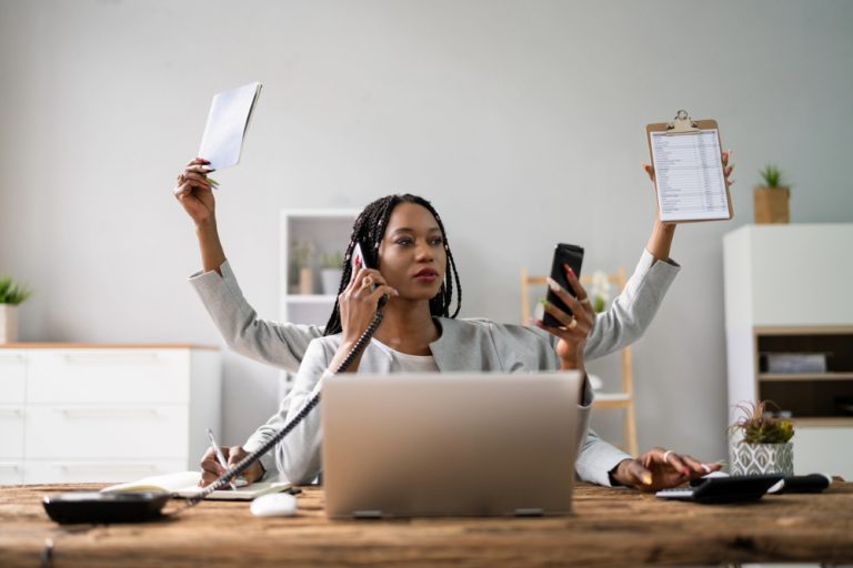 Black woman at desk in need of work-life balance.