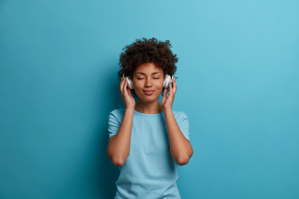 The Songs That Hugged Black Women Before Anybody Else Did
Black woman listening to music on headphones