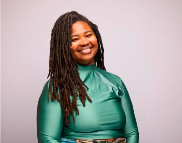 Mia Musa Uses Comedy to Create Connection, Community, and Space for Black Women photo of Comedian Mia Musa in shiny green