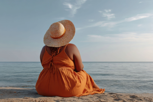 Who Are You Now 2- Black woman sitting on beach in hat